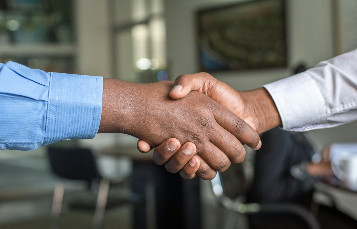 Duas pessoas apertando as mãos após fechar um acordo comercial