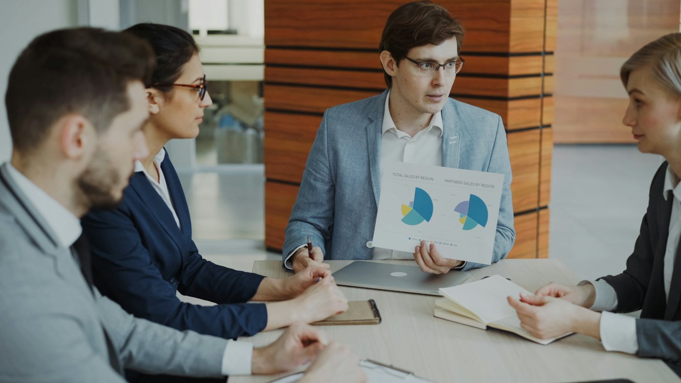 Equipe discutindo gráficos e relatórios financeiros da empresa
