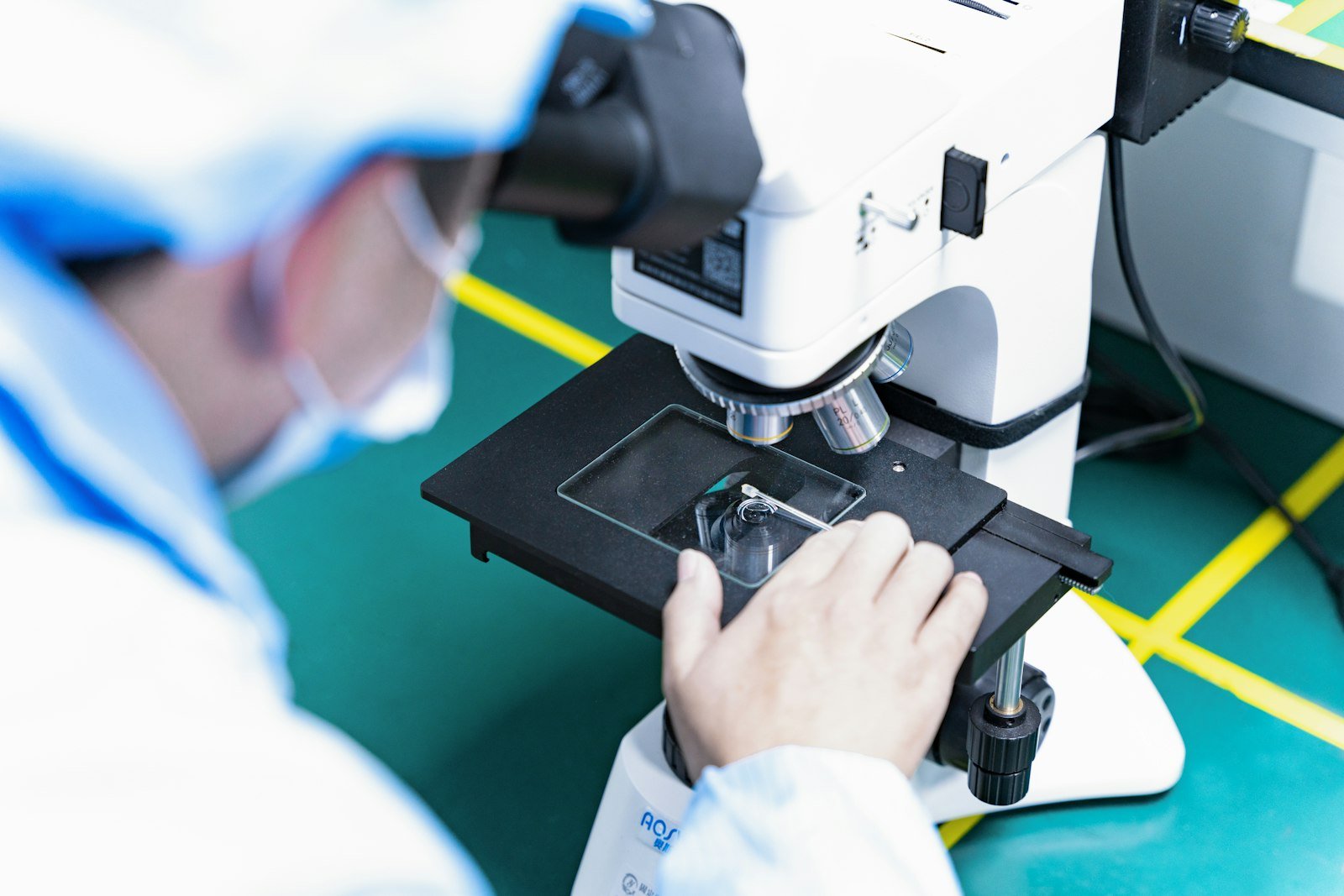 Pesquisadora analisando amostra ao microscópio em laboratório